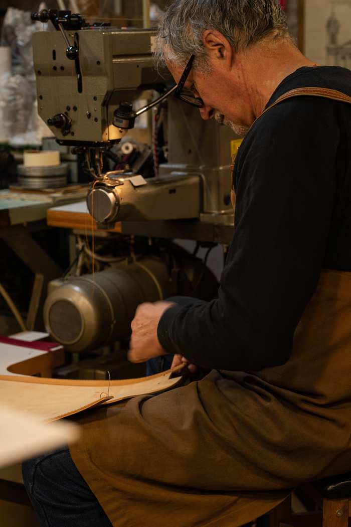 Handwerker näht Etuileder an der Nähmaschine