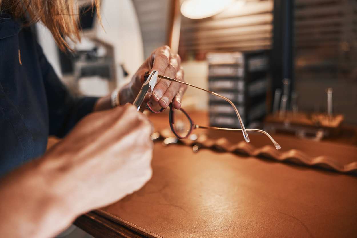 Augenoptiker justiert eine Fassung von Hand